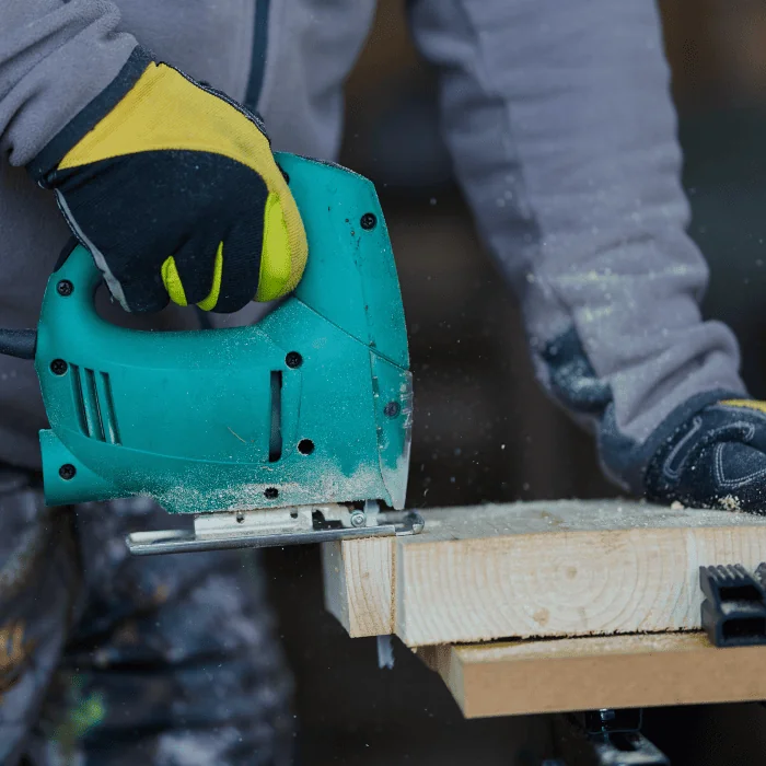Bohrmaschine und Arbeitsmaterial auf einem Holzboden