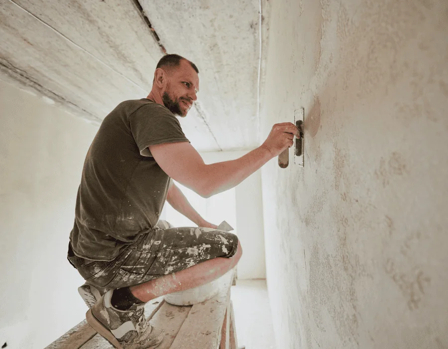 Handwerker streicht eine Wand